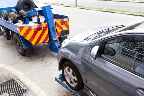tow-truck-towing-a-broken-down-car-on-the-street-3-e1697119222624.jpg